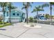 Two-story blue waterfront home featuring a garage, boat dock, and lush landscaping at 6186 Seaside Dr, New Port Richey, FL 34652