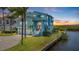 Stunning waterfront home featuring a two-car garage, lush landscaping, and inviting curb appeal at sunset at 6186 Seaside Dr, New Port Richey, FL 34652