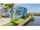 Stylish aqua home featuring a lush green lawn, two-car garage, and waterfront view at 6186 Seaside Dr, New Port Richey, FL 34652