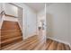 Hallway with hardwood floors leading to an upstairs staircase, multiple doors, and a view to another room at 6186 Seaside Dr, New Port Richey, FL 34652