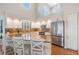 Open concept kitchen featuring granite countertops, white cabinets, and stainless steel appliances under large windows at 6186 Seaside Dr, New Port Richey, FL 34652