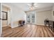 Bright living room with hardwood floors, ceiling fan, and French doors leading to an outdoor space at 6186 Seaside Dr, New Port Richey, FL 34652
