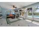 Bright sunroom featuring wicker furniture, ceiling fan, and view of the backyard pool at 6186 Seaside Dr, New Port Richey, FL 34652