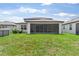 View of the backyard featuring a screened in porch and lush green lawn at 6248 Bradford Woods Dr, Zephyrhills, FL 33542