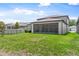Well-maintained backyard with green grass, a fence, and a screened-in lanai area at 6248 Bradford Woods Dr, Zephyrhills, FL 33542