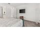Simple but well-lit bedroom featuring a king-sized bed, soft carpet, and a flat-screen television at 6248 Bradford Woods Dr, Zephyrhills, FL 33542