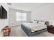 Well-lit bedroom featuring a king-sized bed, soft carpet, and a flat-screen television at 6248 Bradford Woods Dr, Zephyrhills, FL 33542