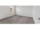 A well-lit bedroom with neutral carpet, base molding, and a window for natural light at 6248 Bradford Woods Dr, Zephyrhills, FL 33542