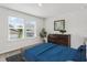Cozy bedroom with blue bedspread, large windows, and dresser at 6248 Bradford Woods Dr, Zephyrhills, FL 33542