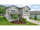 Well-maintained two-story home with a manicured lawn, colorful flowerbed, and attached two-car garage at 6248 Bradford Woods Dr, Zephyrhills, FL 33542