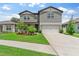 Charming two-story home featuring a lush lawn and an attached two-car garage at 6248 Bradford Woods Dr, Zephyrhills, FL 33542