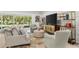 Light-filled living room with a cozy seating arrangement, tile flooring, and views of outdoor greenery at 6248 Bradford Woods Dr, Zephyrhills, FL 33542