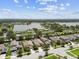 Picturesque aerial view of a suburban neighborhood with a tranquil lake and lush green trees under a cloudy sky at 6467 Seasound Dr, Apollo Beach, FL 33572