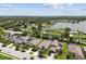 Scenic aerial view of a residential neighborhood with well-manicured lawns and a beautiful lake in the background at 6467 Seasound Dr, Apollo Beach, FL 33572