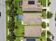 Aerial view showcases neighborhood homes featuring solar panels, mature trees, green lawns, and screened pools at 6467 Seasound Dr, Apollo Beach, FL 33572