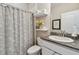 Well-lit bathroom with granite countertops, white cabinets, and decorative gray floral shower curtain at 6467 Seasound Dr, Apollo Beach, FL 33572