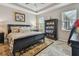 Comfortable bedroom with a dark wood bed frame, tile flooring, and bright natural light at 6467 Seasound Dr, Apollo Beach, FL 33572