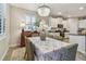Chandelier-lit dining area with window shutters, seamlessly connected to the kitchen at 6467 Seasound Dr, Apollo Beach, FL 33572