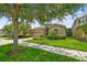 Charming single-Gathering home with a lush lawn and colorful flowerbeds lining the driveway and sidewalk at 6467 Seasound Dr, Apollo Beach, FL 33572