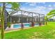 A tranquil screened-in pool with lush landscaping creates a backyard oasis at 6467 Seasound Dr, Apollo Beach, FL 33572