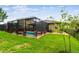 The screened-in pool is enhanced by lush landscaping and a well-manicured lawn at 6467 Seasound Dr, Apollo Beach, FL 33572