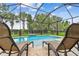 Relaxing screened-in pool area with lounge chairs and a clear view of the backyard landscaping at 6467 Seasound Dr, Apollo Beach, FL 33572