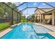 Beautiful screened-in pool with a tanning ledge and lush landscaping visible beyond the enclosure at 6467 Seasound Dr, Apollo Beach, FL 33572