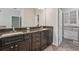 Bathroom vanity with dual sinks, dark cabinets, and a granite countertop at 6706 Riverside Bluffs Dr, Riverview, FL 33578