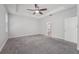 Spacious bedroom featuring plush carpeting, tray ceilings, and a ceiling fan at 6706 Riverside Bluffs Dr, Riverview, FL 33578