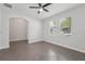 A bright bedroom with neutral walls, tile floors, a modern ceiling fan, and natural light from two windows at 6706 Riverside Bluffs Dr, Riverview, FL 33578