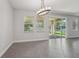 Dining room with tile floor, modern chandelier and sliding glass door to the outside at 6706 Riverside Bluffs Dr, Riverview, FL 33578