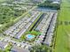 A scenic aerial view highlighting modern townhomes with a community pool, a pond, and lush green spaces at 7124 Summer Holly Pl, Riverview, FL 33578
