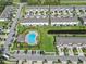 An aerial view of a neighborhood showcasing a community pool, modern townhomes, and green spaces at 7124 Summer Holly Pl, Riverview, FL 33578