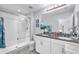 Well-lit bathroom with double vanity, granite countertops, and a glass-enclosed shower providing a luxurious feel at 7124 Summer Holly Pl, Riverview, FL 33578