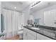 Bright bathroom featuring a shower-tub combo, granite counters, and white cabinets with ample storage at 7124 Summer Holly Pl, Riverview, FL 33578