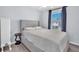 Well-lit bedroom with a comfortable bed, side table, and window offering serene view and bright light at 7124 Summer Holly Pl, Riverview, FL 33578