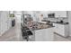 Spacious kitchen with white cabinets, stainless steel appliances, and a granite island with bar stools at 7124 Summer Holly Pl, Riverview, FL 33578