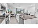Bright kitchen featuring stainless steel appliances, white cabinets and a large island with seating at 7124 Summer Holly Pl, Riverview, FL 33578