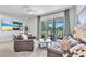 Comfortable living room with tile floors, modern furniture, and sliding glass doors to the backyard at 7124 Summer Holly Pl, Riverview, FL 33578