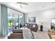 Cozy living room featuring a comfortable couch, sliding glass doors to the screened lanai, and neutral decor at 7124 Summer Holly Pl, Riverview, FL 33578