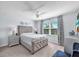 Calm and inviting main bedroom with a tufted headboard bed, side tables, and a bright window at 7124 Summer Holly Pl, Riverview, FL 33578
