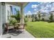 Cozy backyard patio with seating overlooks a lush lawn and fenced perimeter at 7517 Notched Pine Bnd, Wesley Chapel, FL 33545