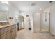 Well-lit bathroom featuring tile flooring, a granite countertop, double vanity and a glass-enclosed shower at 7517 Notched Pine Bnd, Wesley Chapel, FL 33545