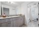 Bathroom featuring granite countertop, wood cabinets, tile flooring, and a shower/tub combo, offering functionality and style at 7517 Notched Pine Bnd, Wesley Chapel, FL 33545
