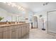 Elegant bathroom featuring double vanity, granite countertops, and a glass-enclosed shower at 7517 Notched Pine Bnd, Wesley Chapel, FL 33545
