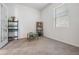 Bright bedroom featuring neutral carpet, a black shelf, and a small table under a window at 7517 Notched Pine Bnd, Wesley Chapel, FL 33545