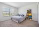 Inviting bedroom features a bed, planets poster, plush toys, and window, offering a cozy and personalized space at 7517 Notched Pine Bnd, Wesley Chapel, FL 33545