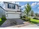Two-story home with a two-car garage, manicured lawn, and well-maintained landscaping at 7517 Notched Pine Bnd, Wesley Chapel, FL 33545