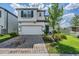Two-story home featuring a two-car garage, manicured lawn, and well-maintained landscaping at 7517 Notched Pine Bnd, Wesley Chapel, FL 33545