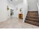 Welcoming foyer features tiled floor, wooden stairs, cabinet and decor, providing an inviting entrance at 7517 Notched Pine Bnd, Wesley Chapel, FL 33545